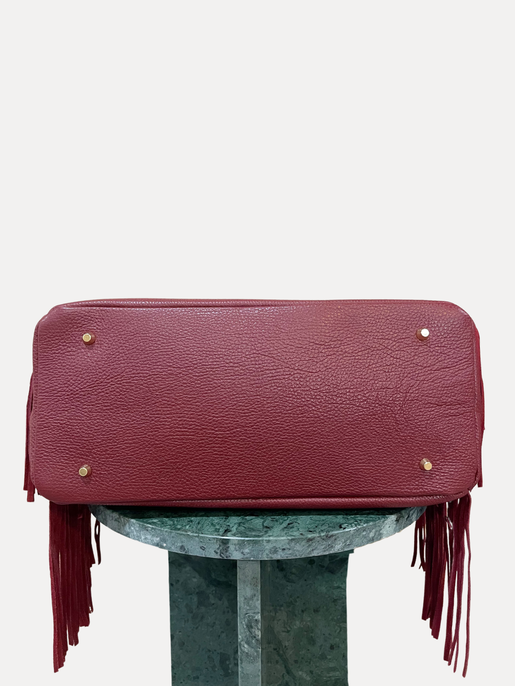 GOLDxTEAL gorgeous timeless pebbled grained leather satchel with fringe in the color Bordeaux.