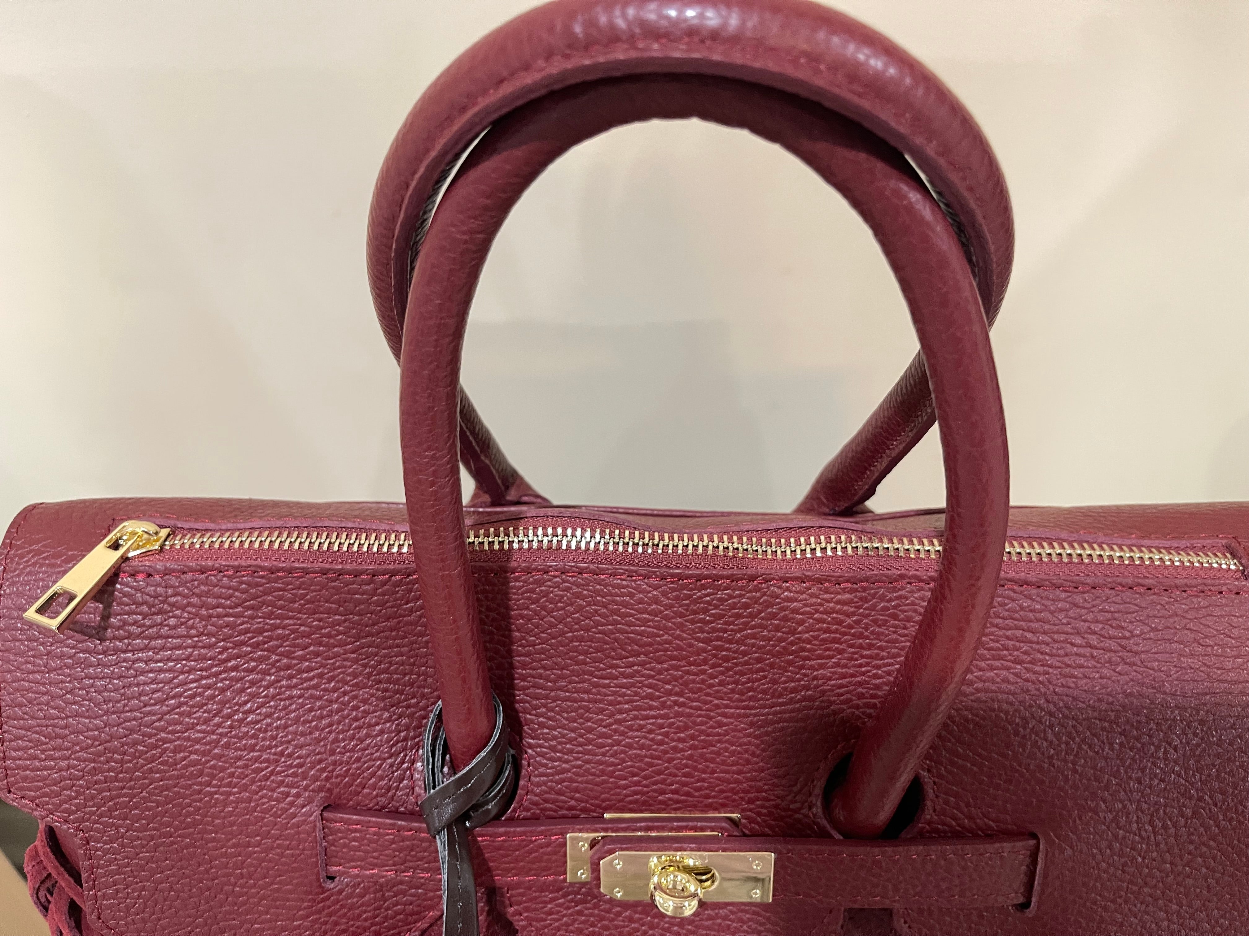 GOLDxTEAL gorgeous timeless pebbled grained leather satchel with fringe in the color Bordeaux.