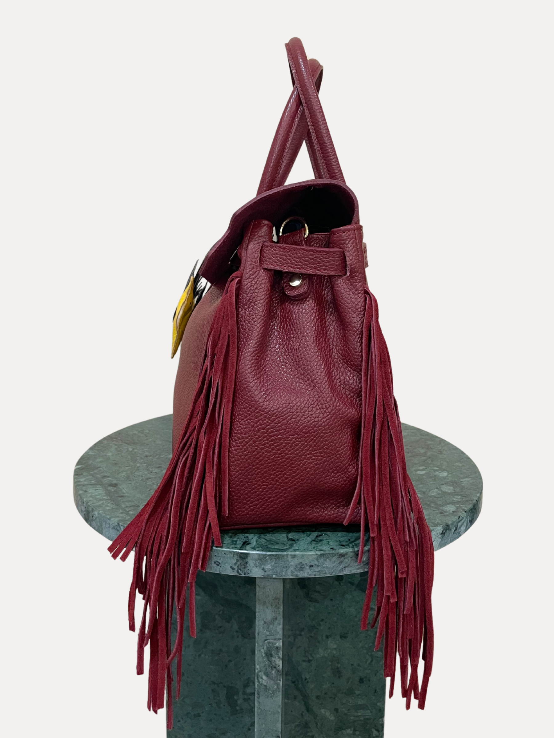 GOLDxTEAL gorgeous timeless pebbled grained leather satchel with fringe in the color Bordeaux.