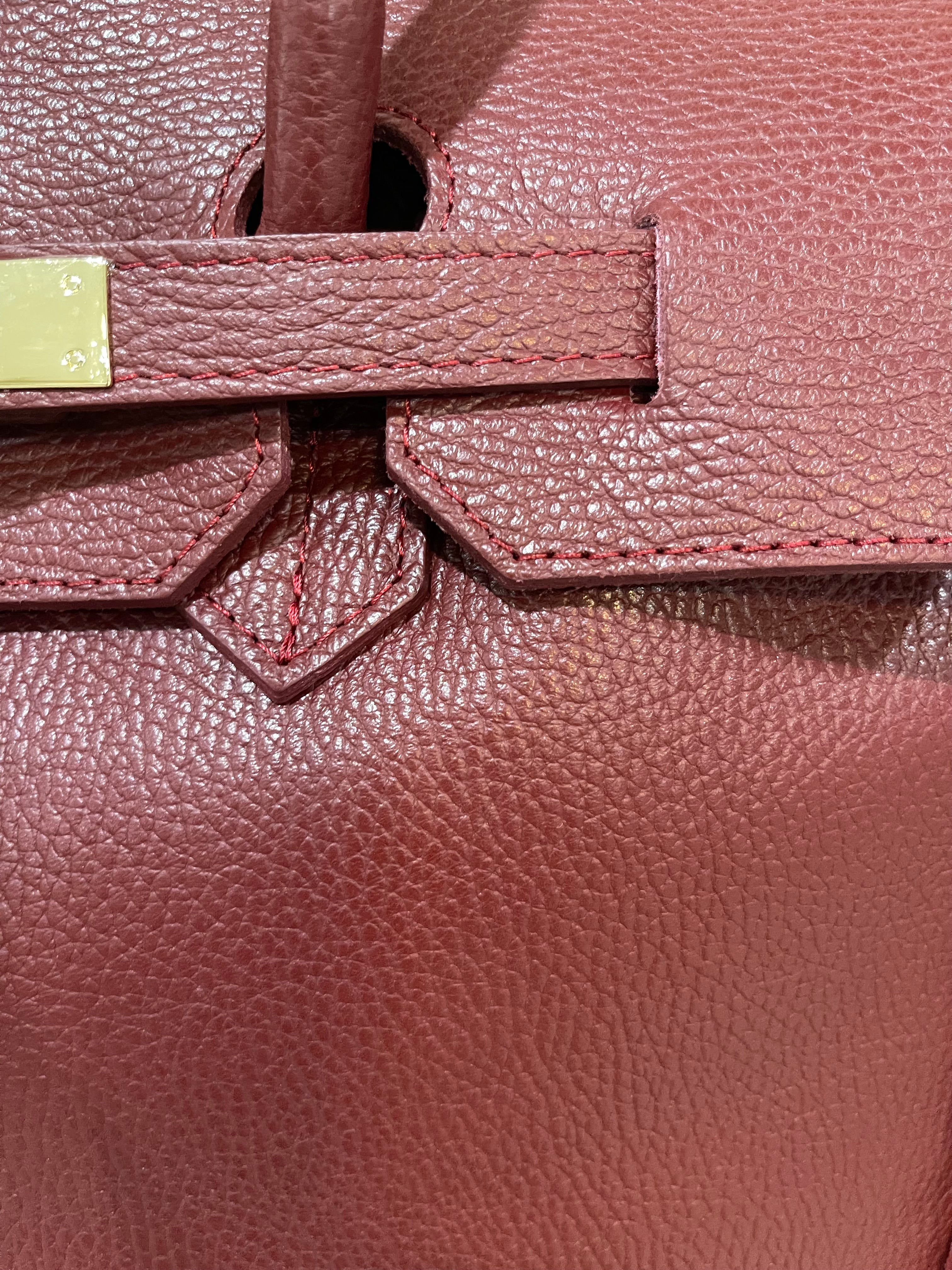 GOLDxTEAL gorgeous timeless pebbled grained leather satchel with fringe in the color Bordeaux.