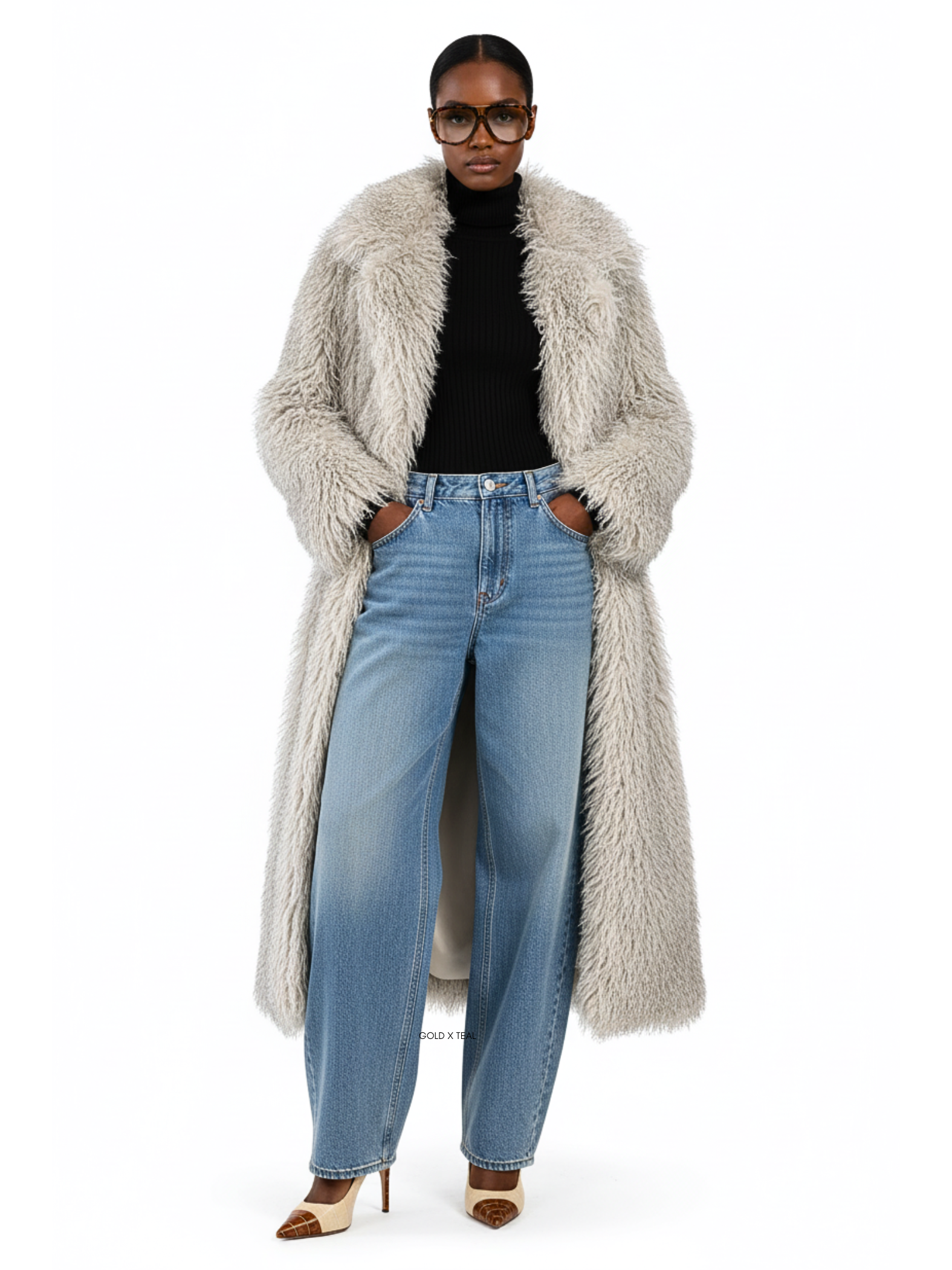 Model wearing the GOLD x TEAL Frost Luxe Coat in faux Mongolian fur, front view showing full-length silhouette and chic lapel collar.