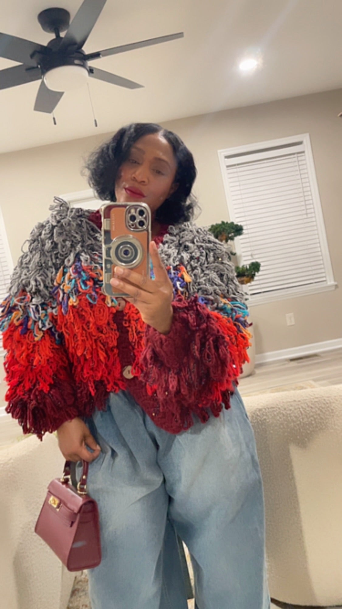 GOLD x TEAL ARTE LOOP SWEATER ON MODEL IRL WITH JEANS AND BAG.