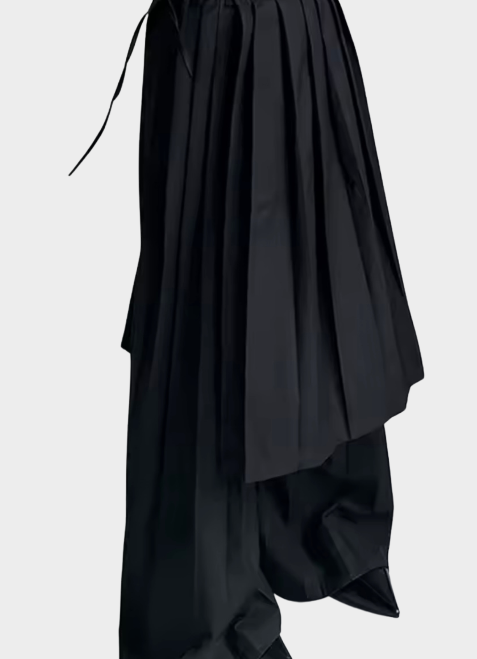 Side view of GOLD x TEAL Monarch Pleat Trousers displaying wide-leg drape and removable pleated skirt overlay.