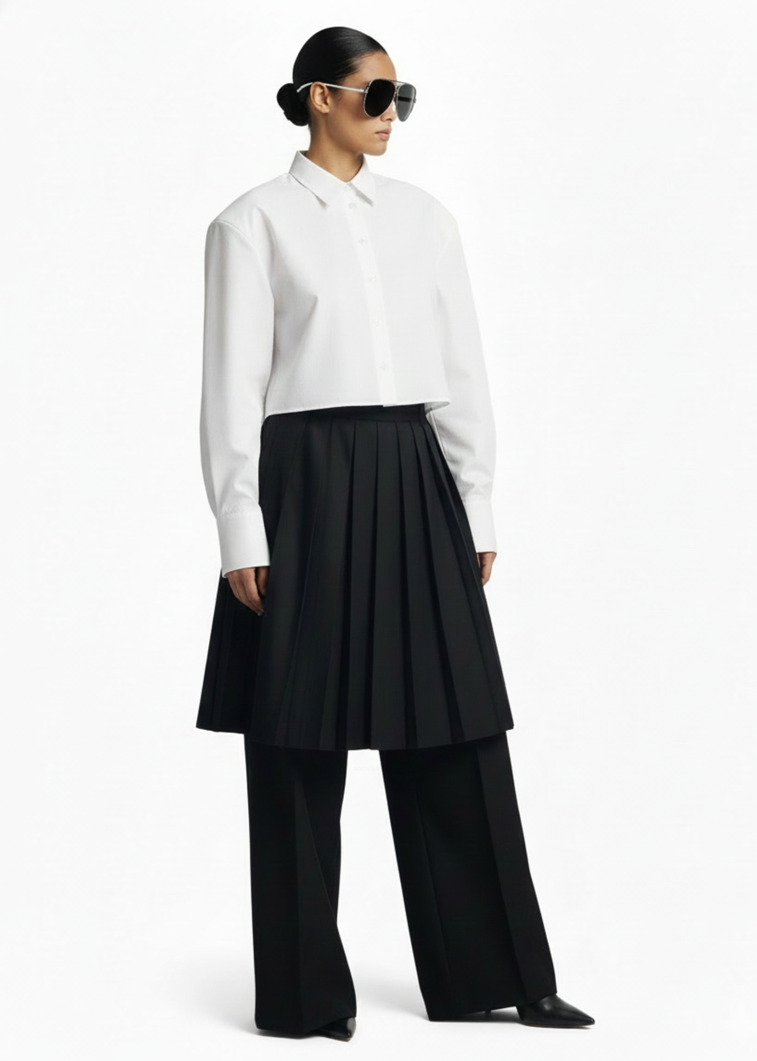 Side profile of the GOLD x TEAL Monarch Pleat Trousers featuring structured pleated skirt overlay and wide-leg design.