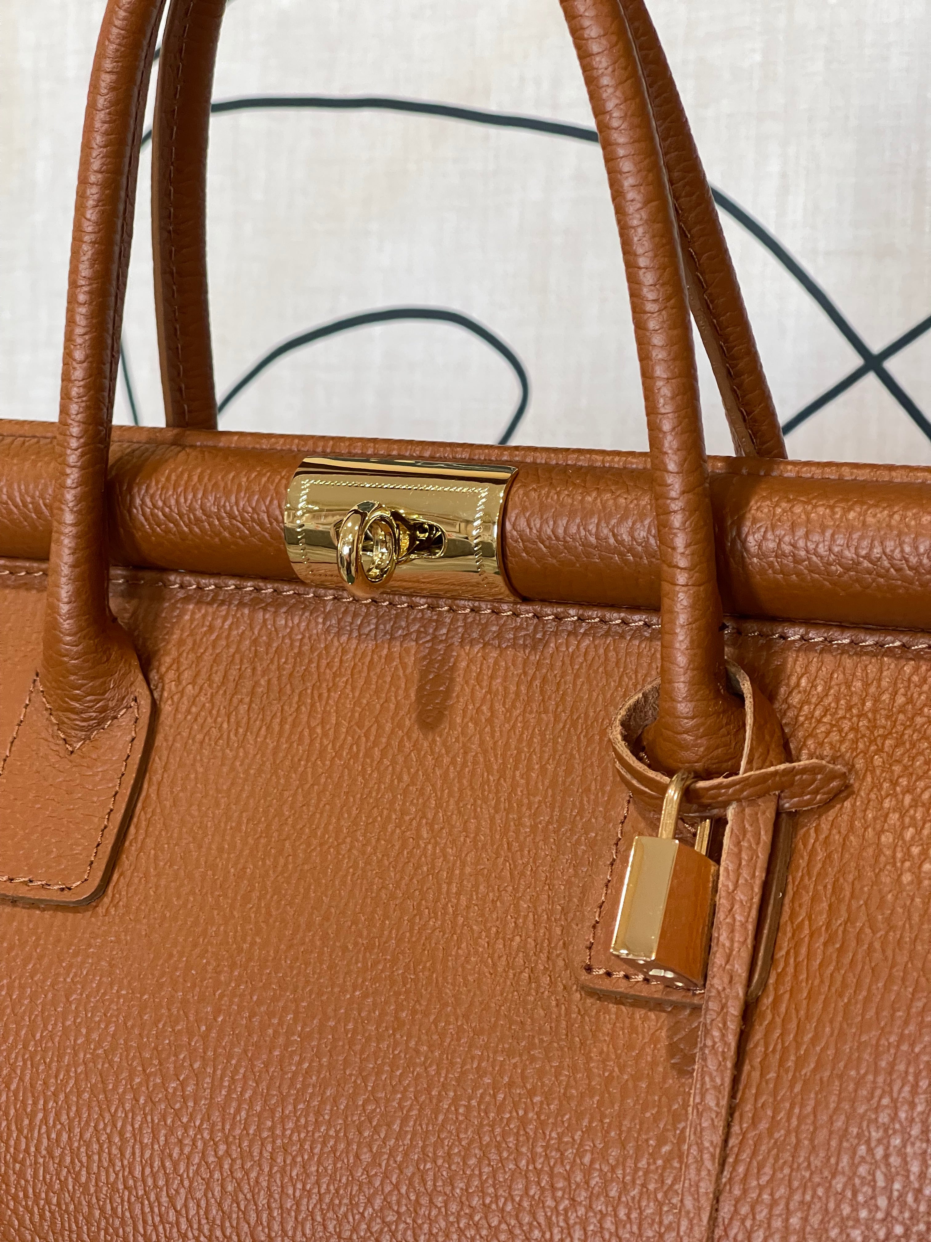 GOLDxTEAL gorgeous amber leather color handbag with gold metal lock.