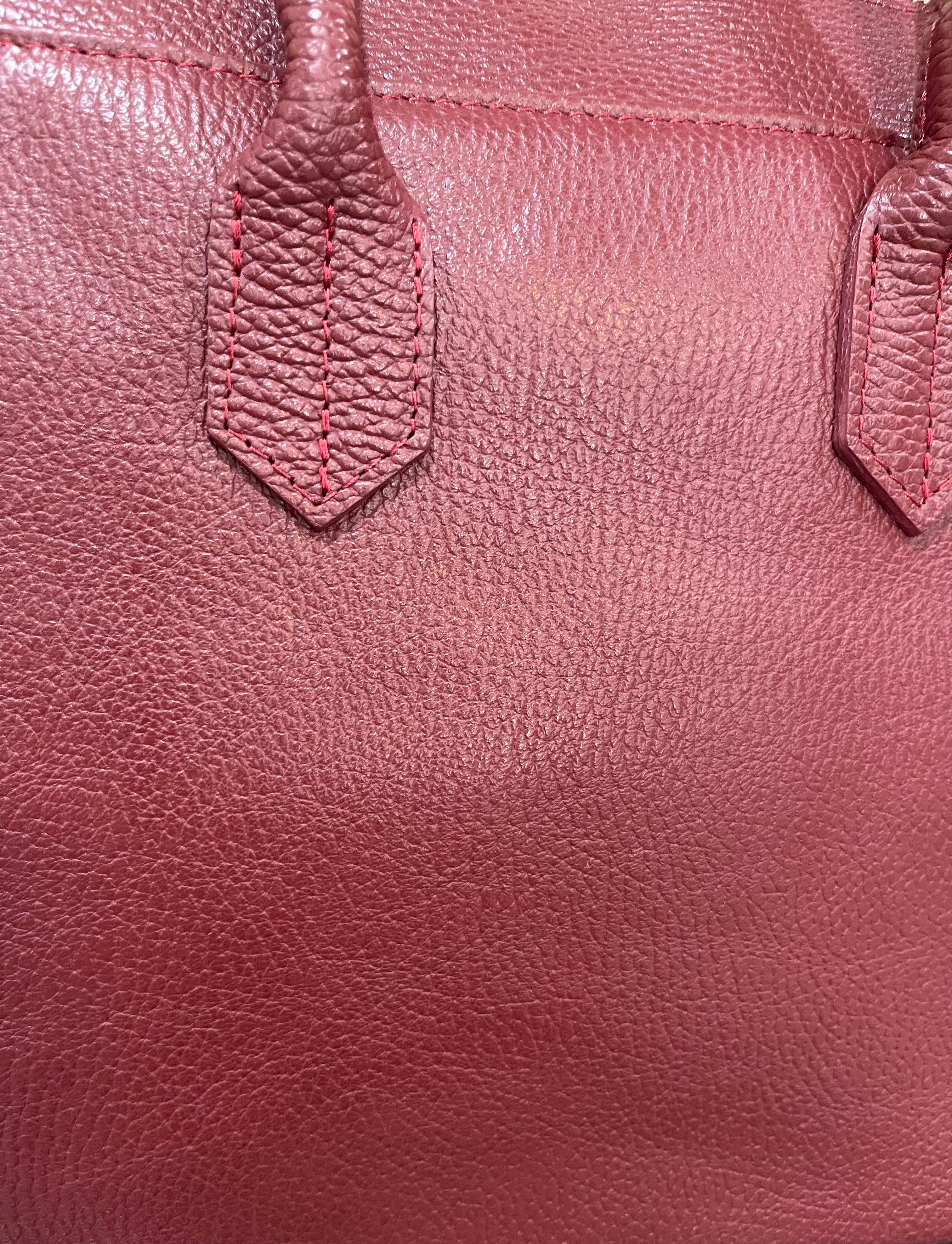 GOLDxTEAL gorgeous timeless pebbled grained leather satchel with fringe in the color Bordeaux.