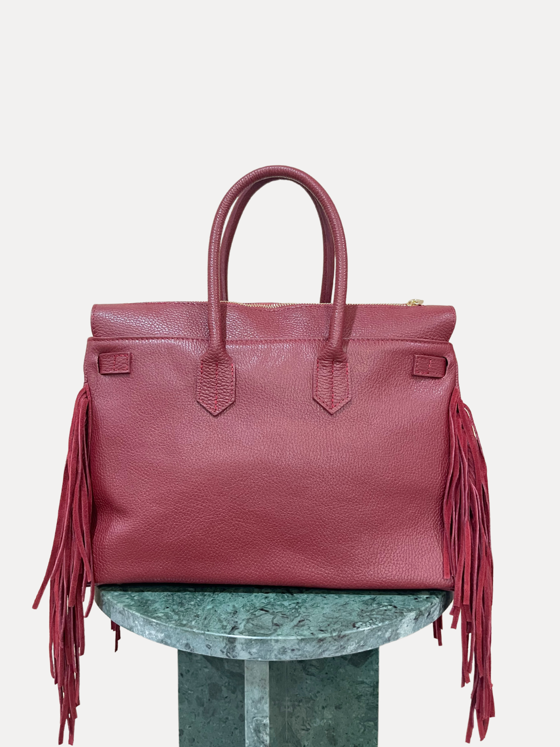 GOLDxTEAL gorgeous timeless pebbled grained leather satchel with fringe in the color Bordeaux.