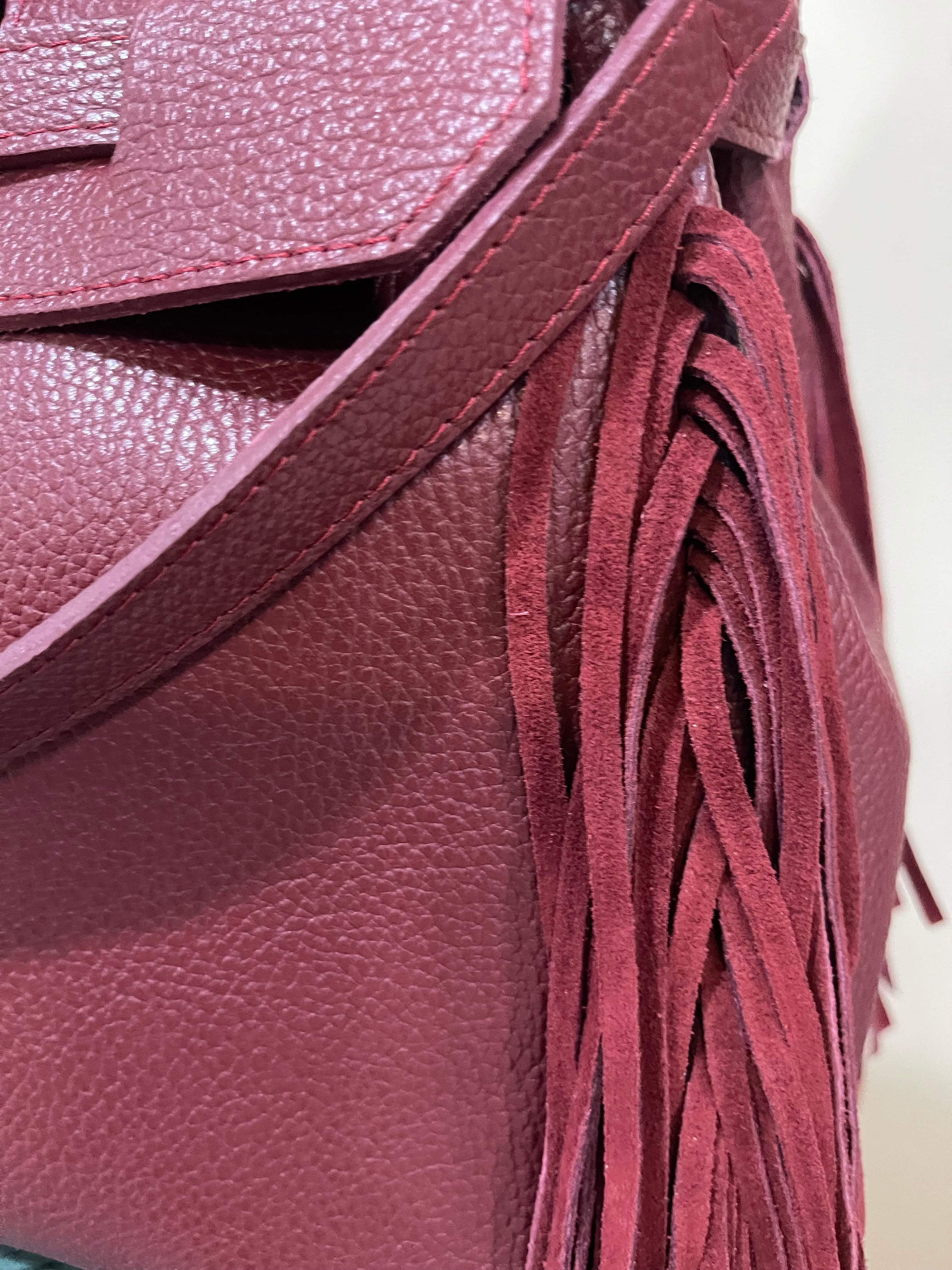 GOLDxTEAL gorgeous timeless pebbled grained leather satchel with fringe in the color Bordeaux.