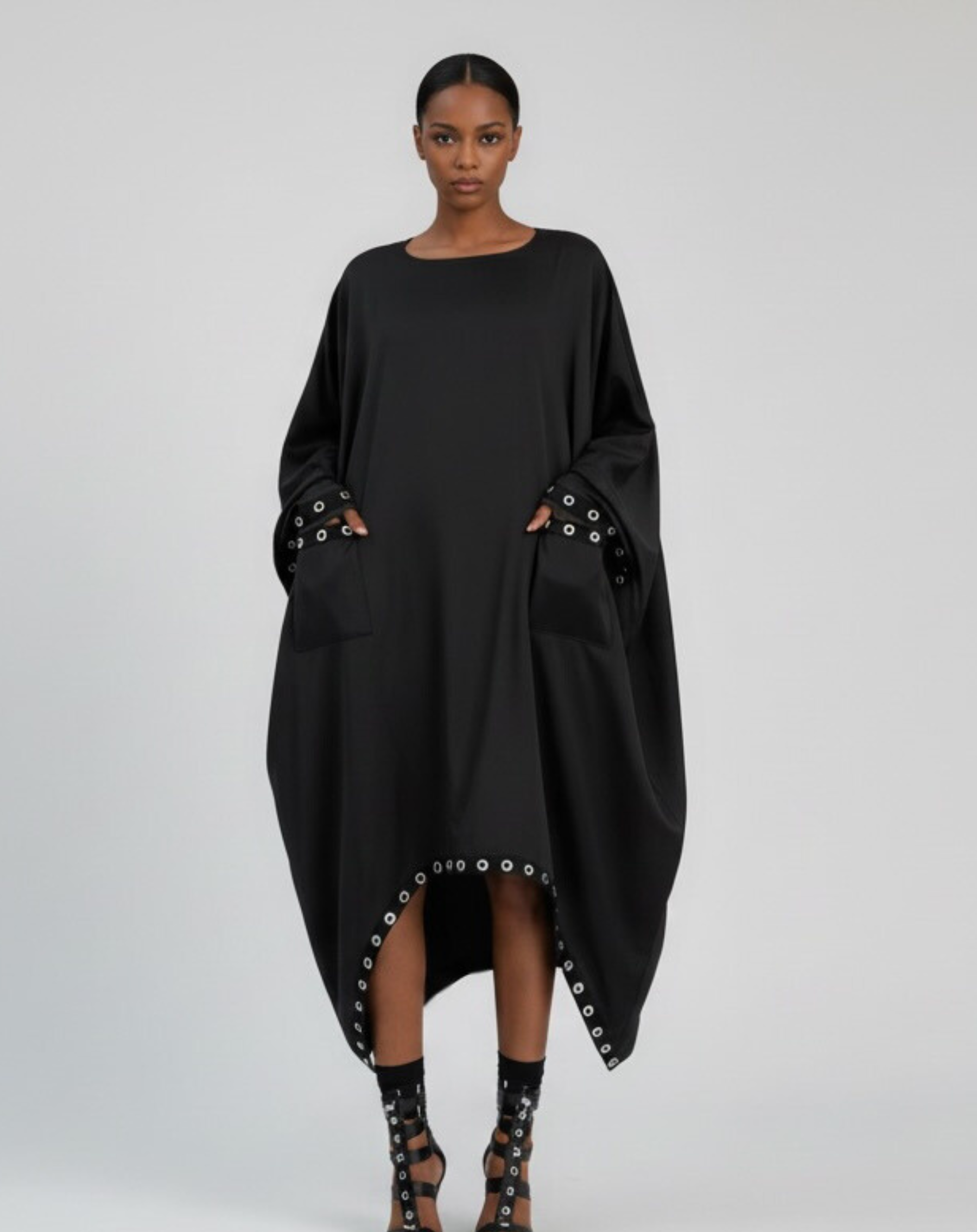 GOLD x TEAL oversized black cocoon dress with silver grommet pocket detail, front view. 