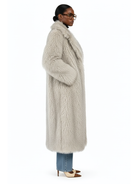 Side profile of the GOLD x TEAL Frost Luxe Coat highlighting plush faux Mongolian fur texture, long silhouette, and draped side detail.