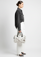 Atlas calf hair bag carried by model showing scale and structured silhouette.