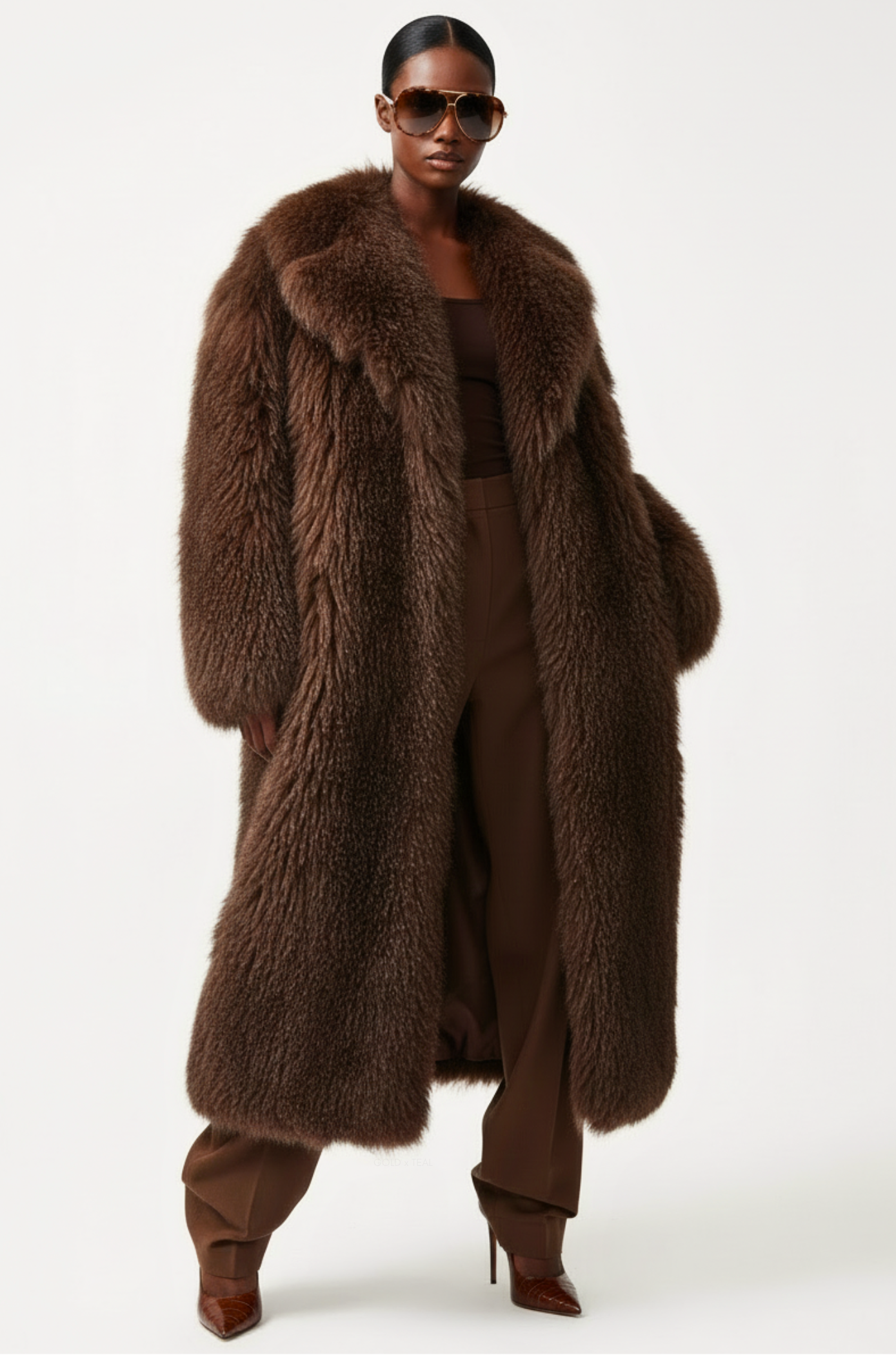 Model wearing the GOLD x TEAL Aurelia Fur Coat in mocha, luxury longline fur coat styled open with rich textured finish.
