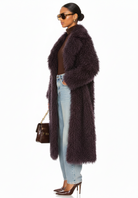 GOLDxTEAL side profile of the Bordeaux Opulence faux Mongolian fur coat showing long silhouette and textured fur detail.