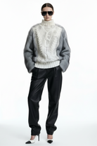 GOLD x TEAL Maison Fur Sweater in white shown on model, cable knit turtleneck sweater with faux fur sleeves and faux fur back panel. Relaxed look.