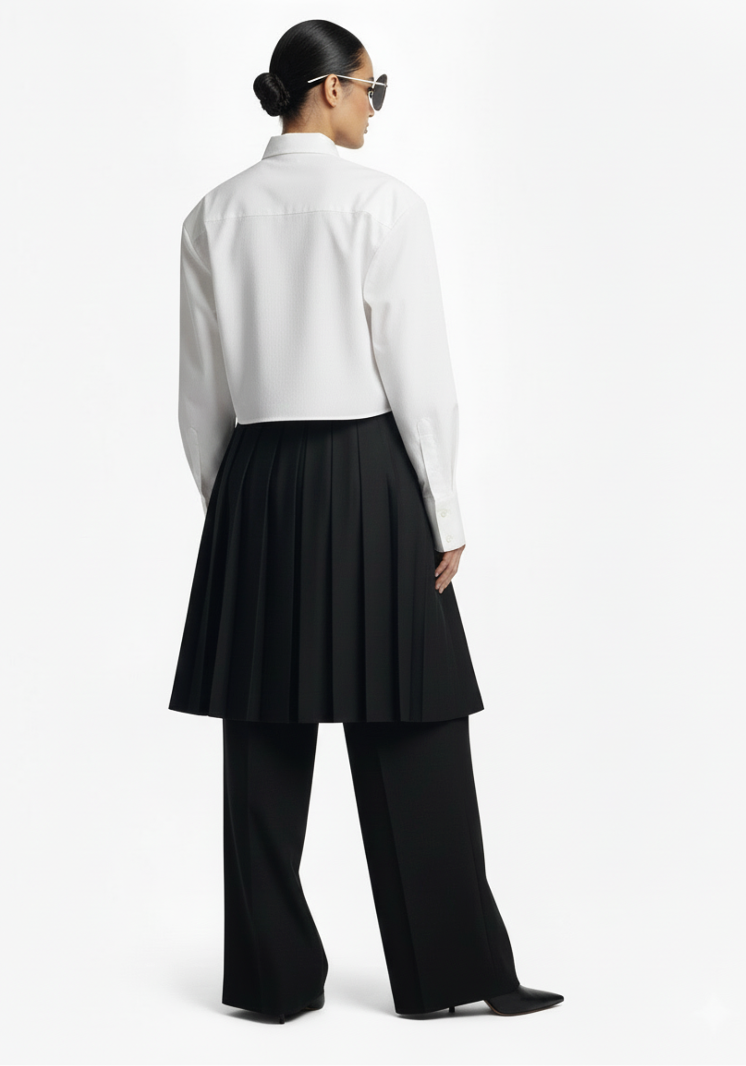 Back view of GOLD x TEAL Monarch Pleat Trousers highlighting pleated skirt overlay and full wide-leg pant silhouette.