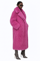 Side view of Rosé Opulence faux Mongolian fur coat by GOLD x TEAL, plush long pink luxury outerwear.