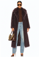 GOLDxTEAL model wearing the Bordeaux Opulence Coat in faux Mongolian fur, full-length front view, styled with jeans and a handbag.