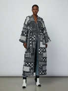 GOLDxTEAL Front view of the Noir Mosaic Duster, a thick knit patchwork coat with kimono sleeves and optional waist belt in black and white textured patterns.