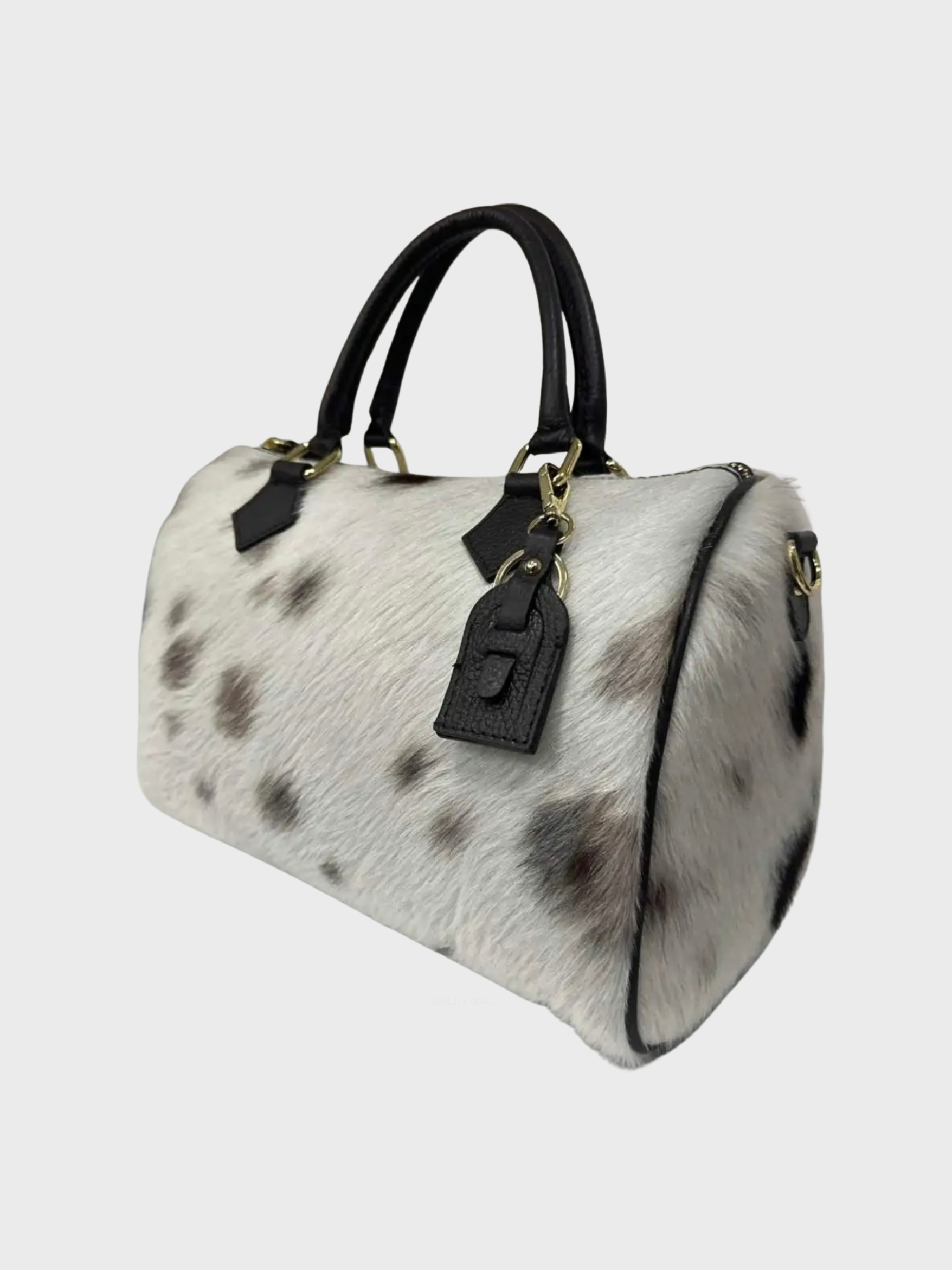 Atlas calf hair handbag with leather rolled handles and gold tone hardware.