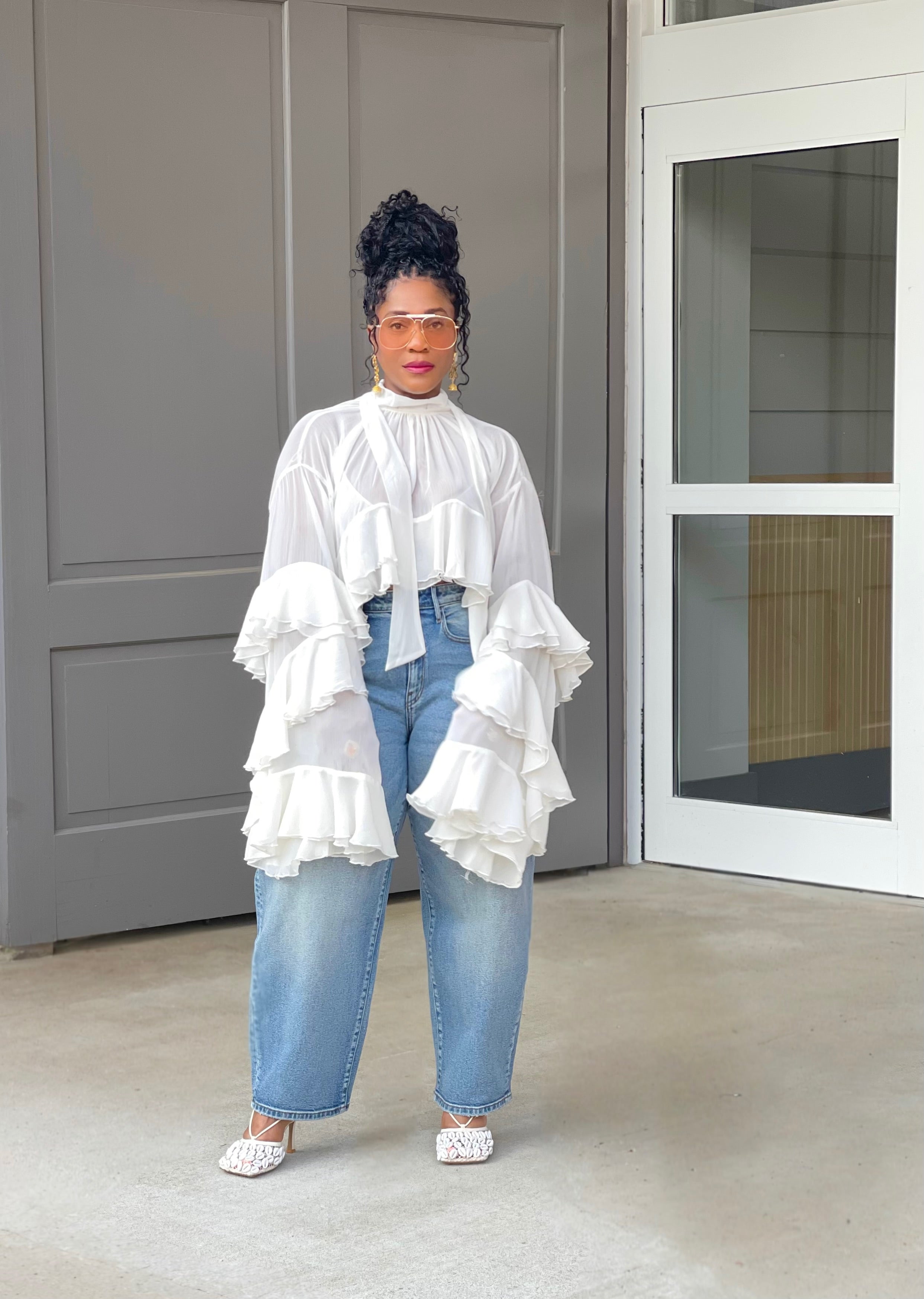Model wearing a gorgeous GOLDxTEAL cascading ruffle top with dramatic romantic sleeves.