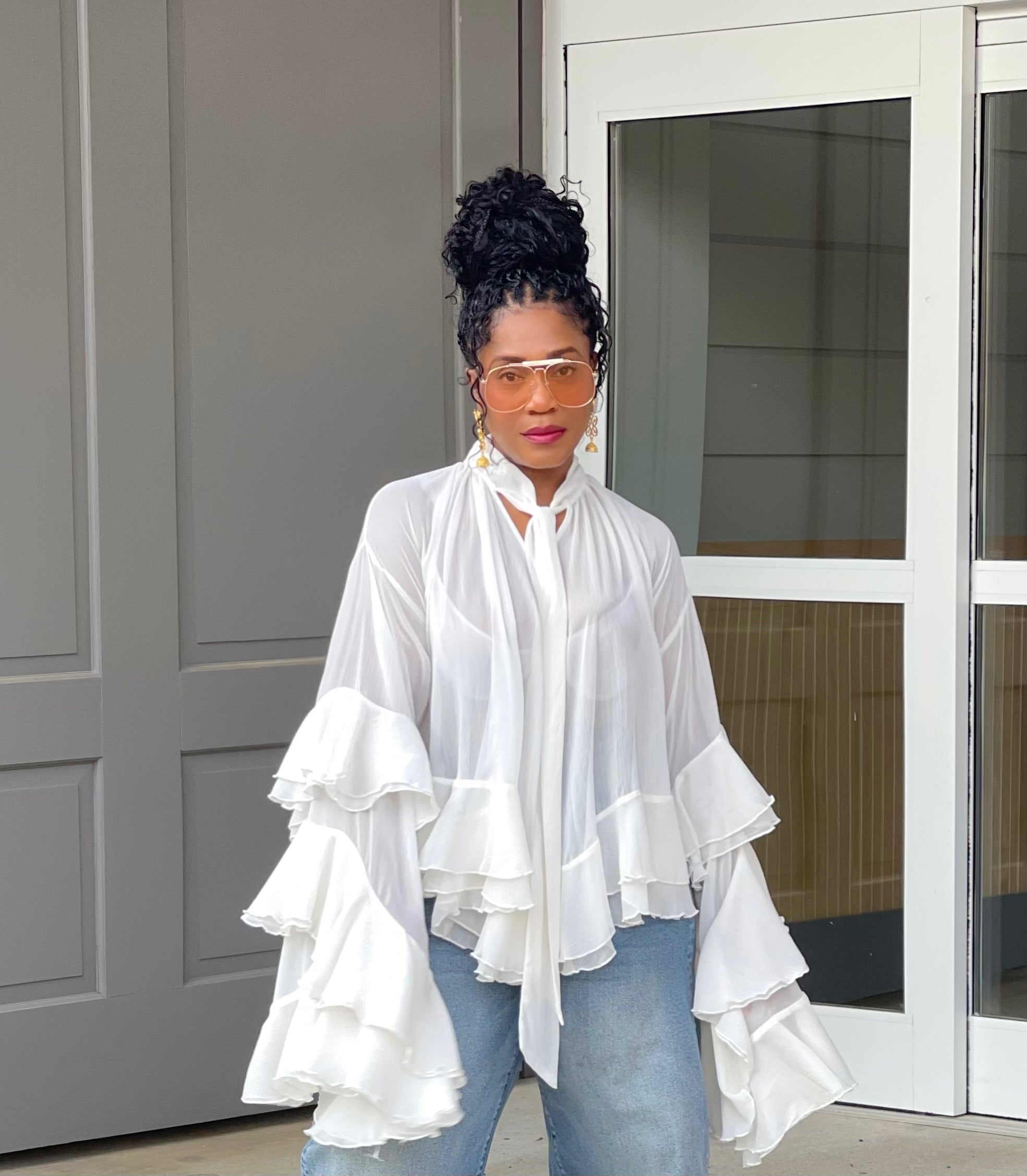 Model wearing a gorgeous GOLDxTEAL cascading ruffle top with dramatic romantic sleeves.