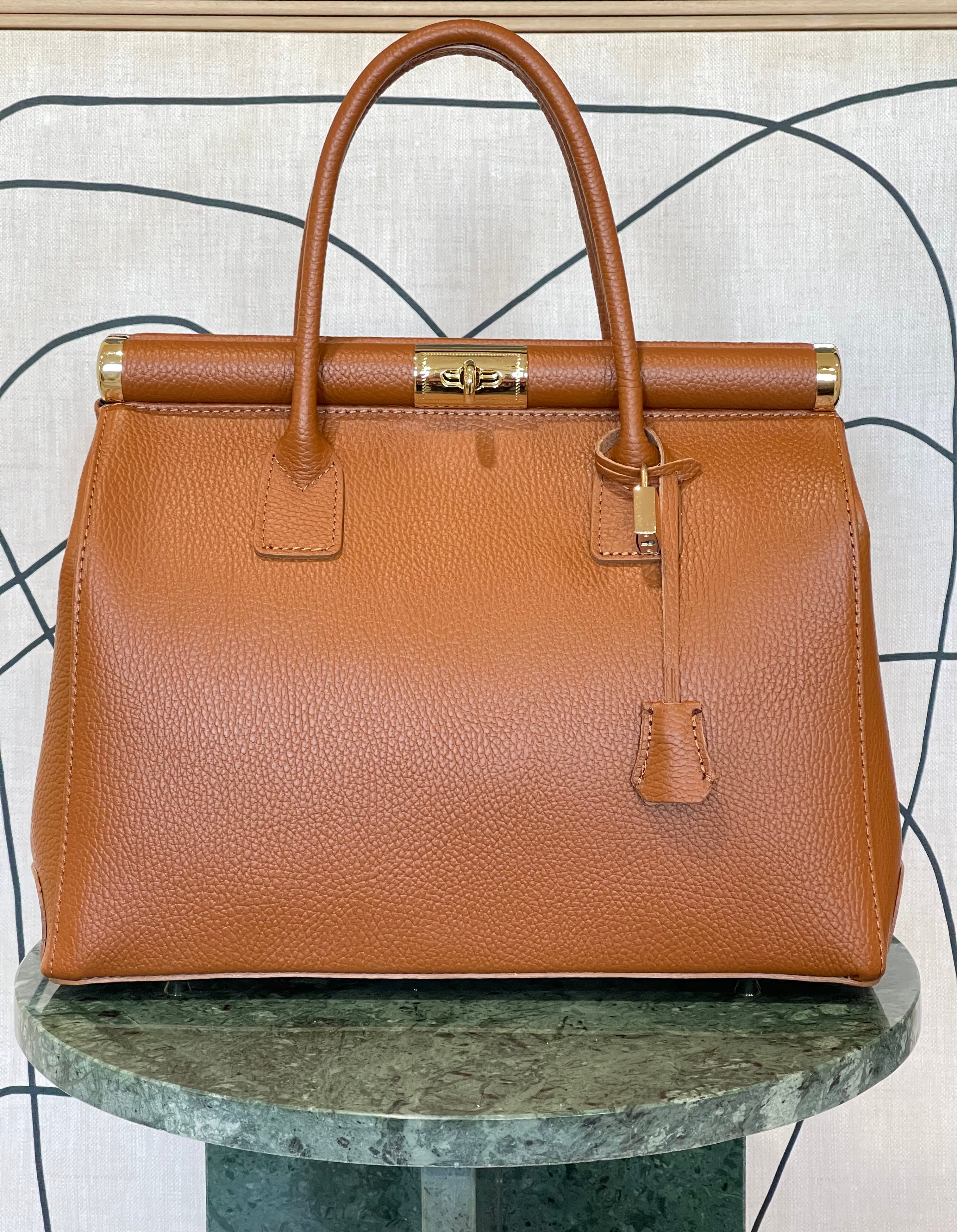 GOLDxTEAL gorgeous amber leather color handbag with gold metal lock.