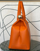 GOLDxTEAL gorgeous orange leather gold metal lock handbag.