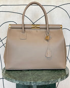 GOLDxTEAL gorgeous taupe leather handbag with gold tone lock.