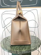 GOLDxTEAL gorgeous taupe leather handbag with gold tone lock.