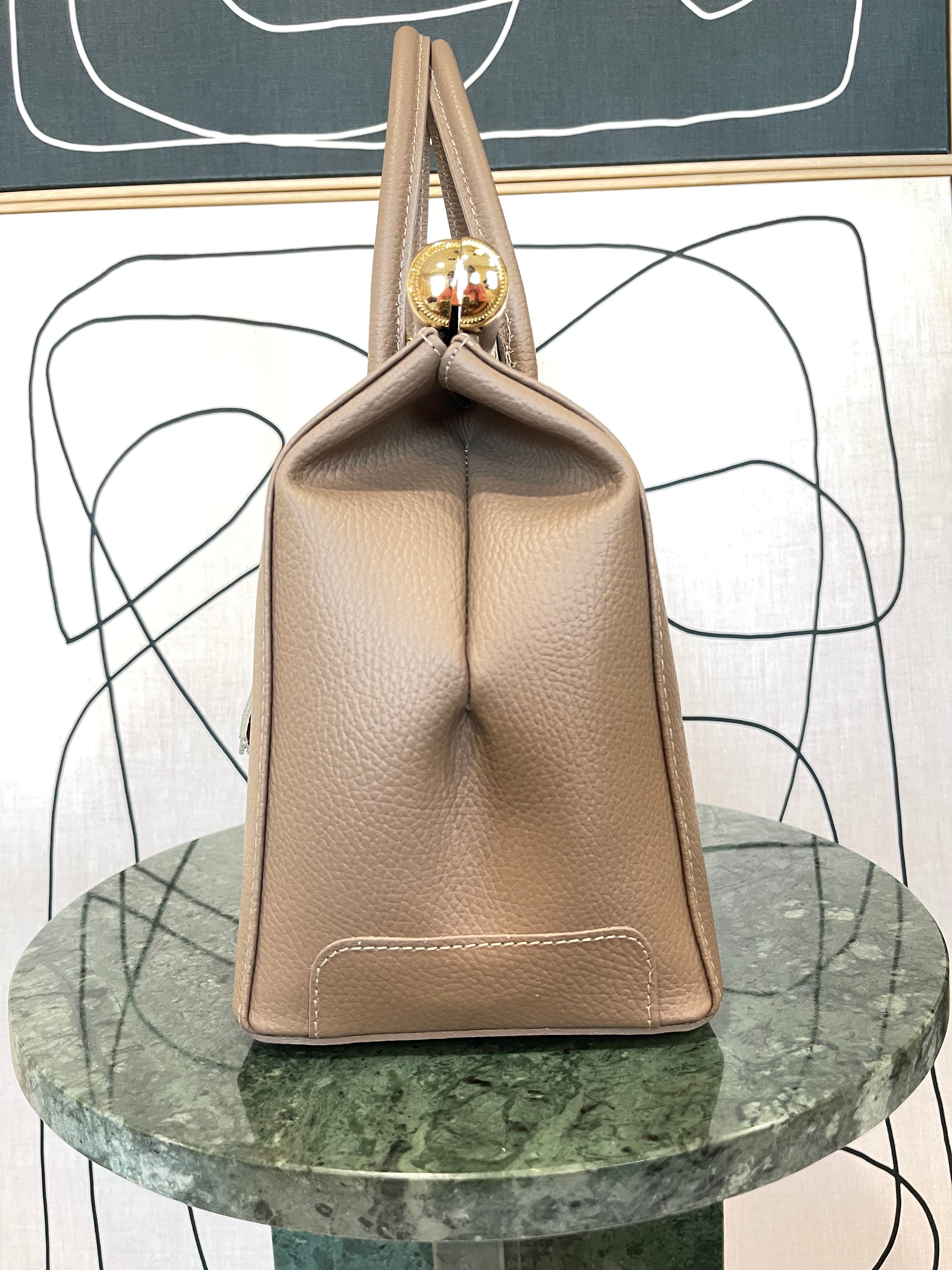 GOLDxTEAL gorgeous taupe leather handbag with gold tone lock.