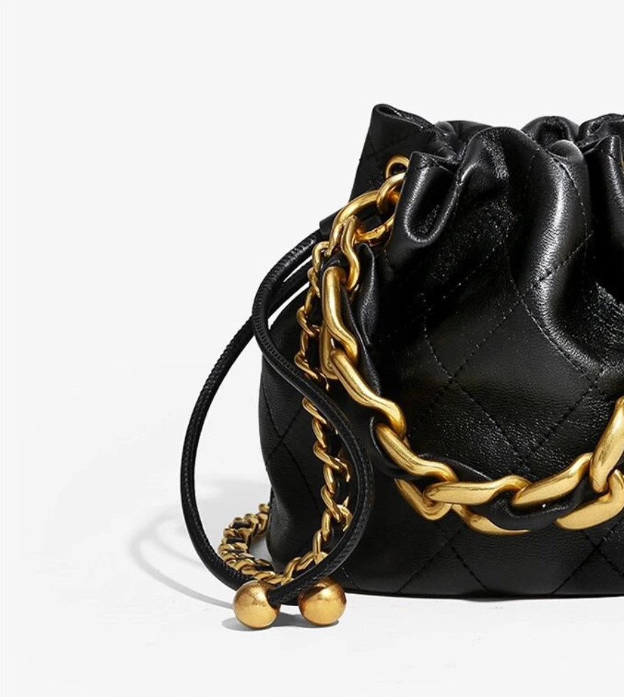 GOLDxTEAL black leather mini bucket bag with a gold woven chain  handle.