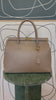 GOLDxTEAL gorgeous taupe leather handbag with gold tone lock.