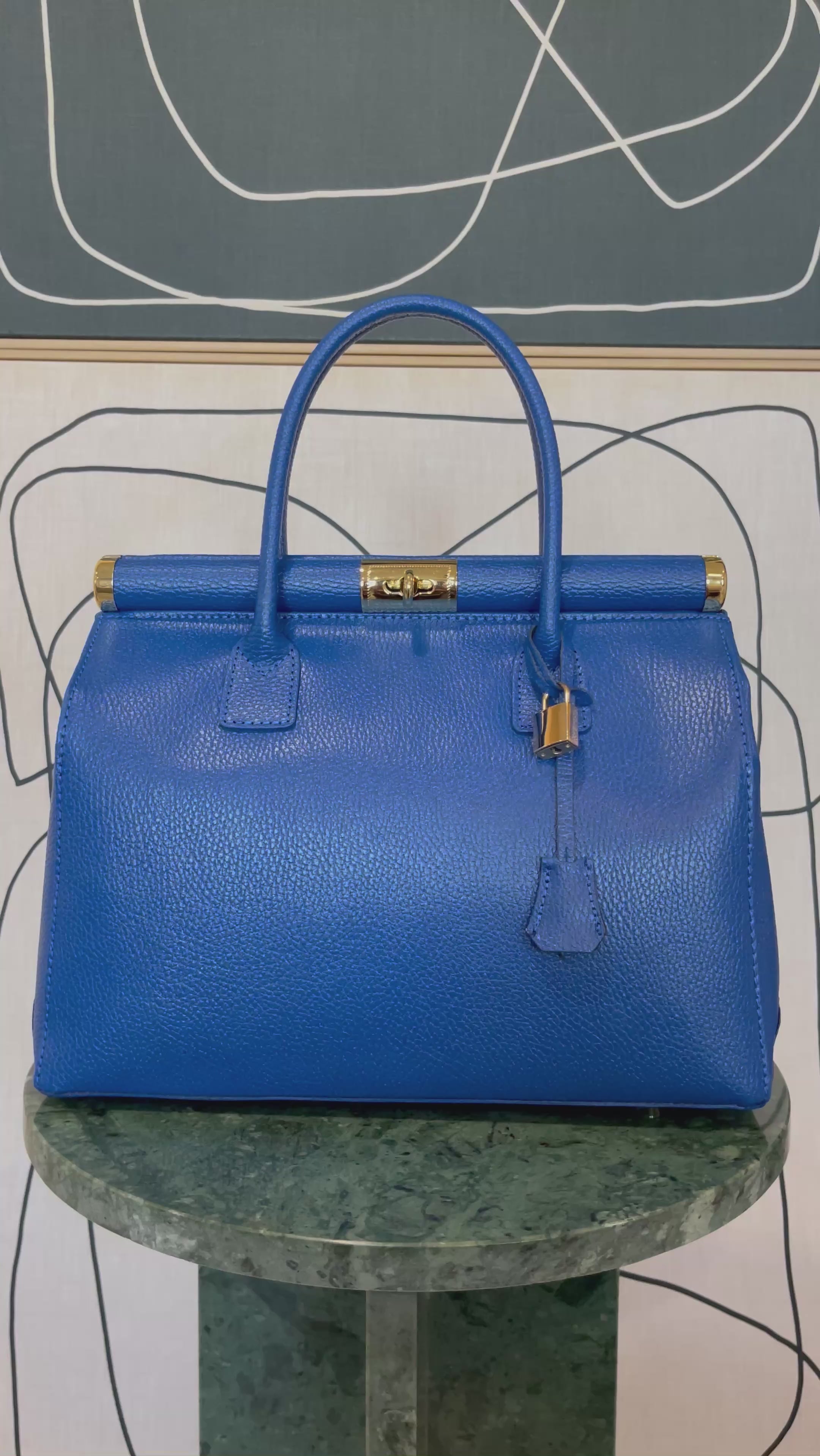 GOLDxTEAL gorgeous blue electric leather handbag with gold tone metal lock.